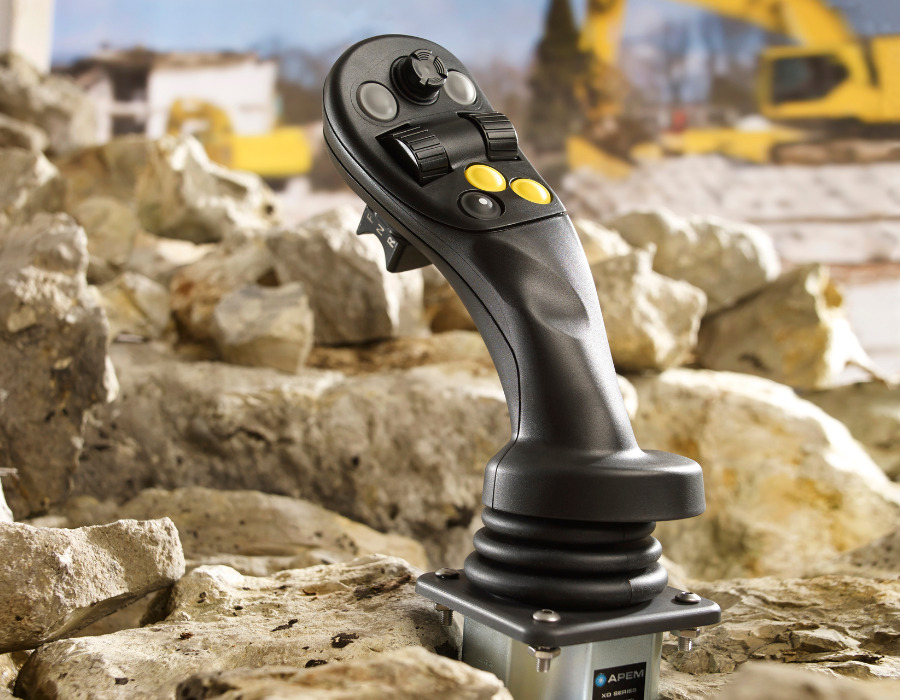 Industrial joystick controller in a construction site setting.