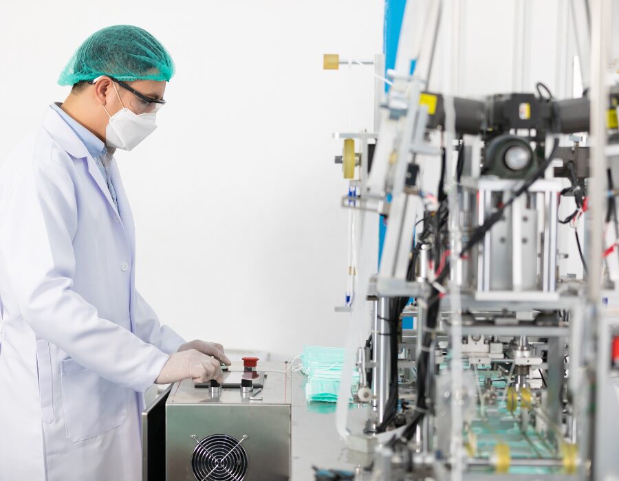 Technician operating machinery in a sterile lab environment.