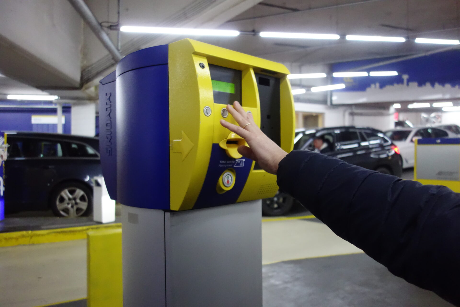 Frau drückt einen Parkscheinautomaten