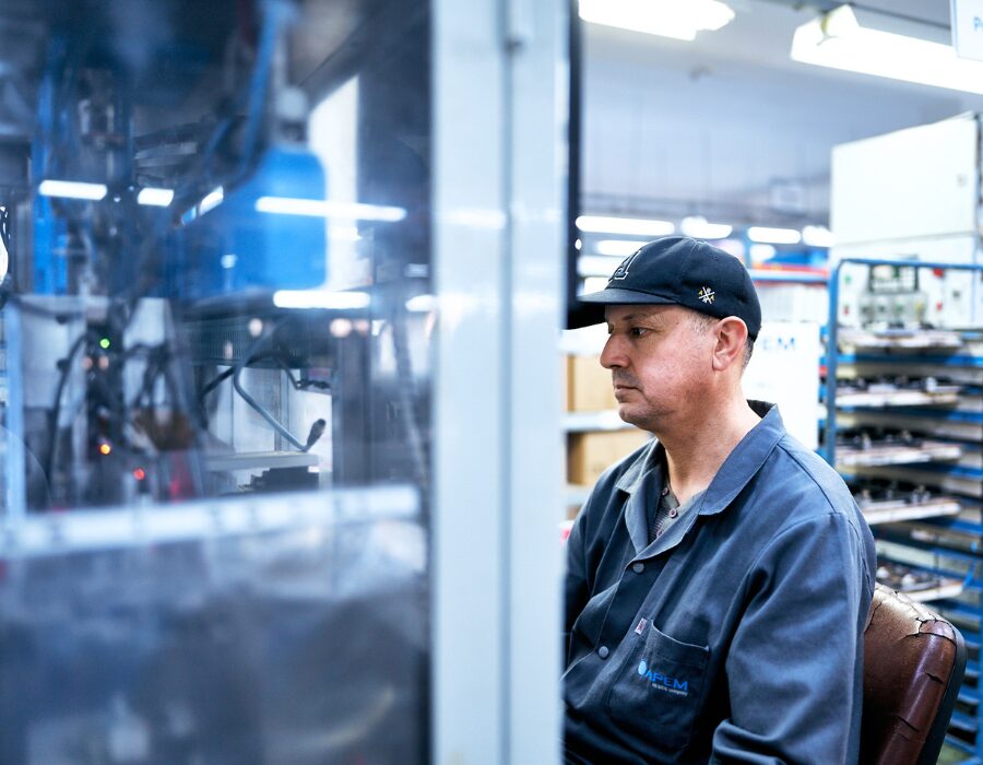 Factory worker monitoring machinery in a production facility.