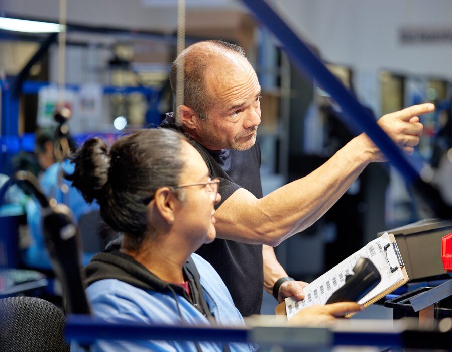 Supervisor giving instructions to an employee on the production floor.