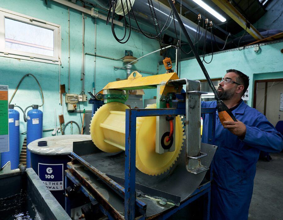 Worker operating industrial equipment in a manufacturing facility.