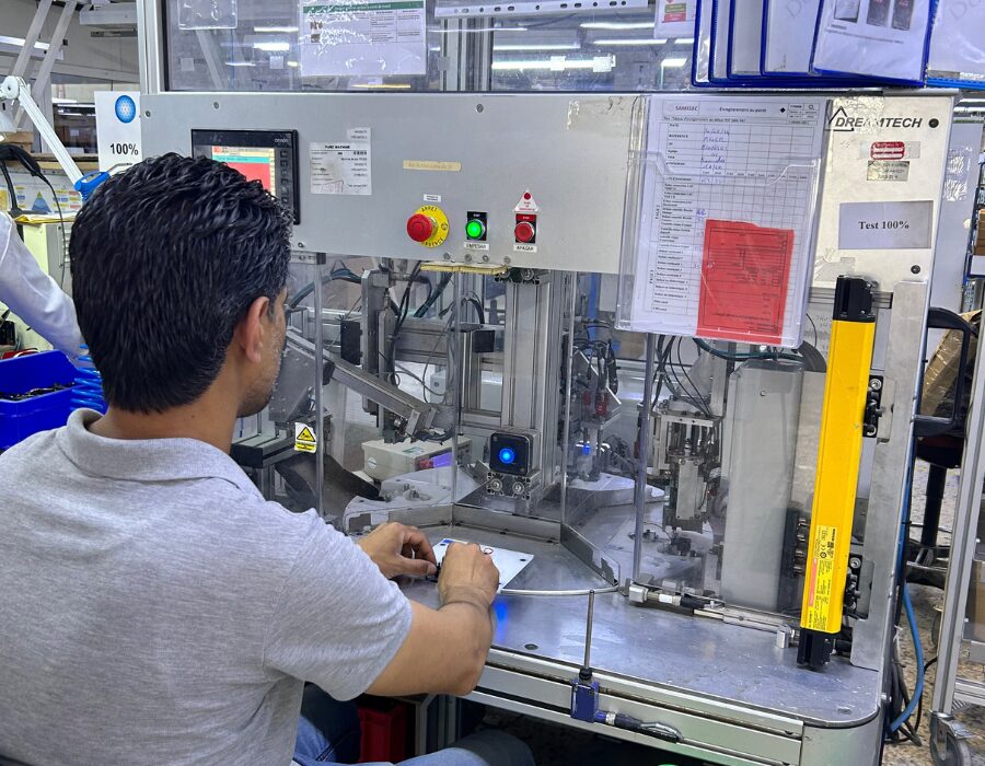 Technician operating a test station in a factory.