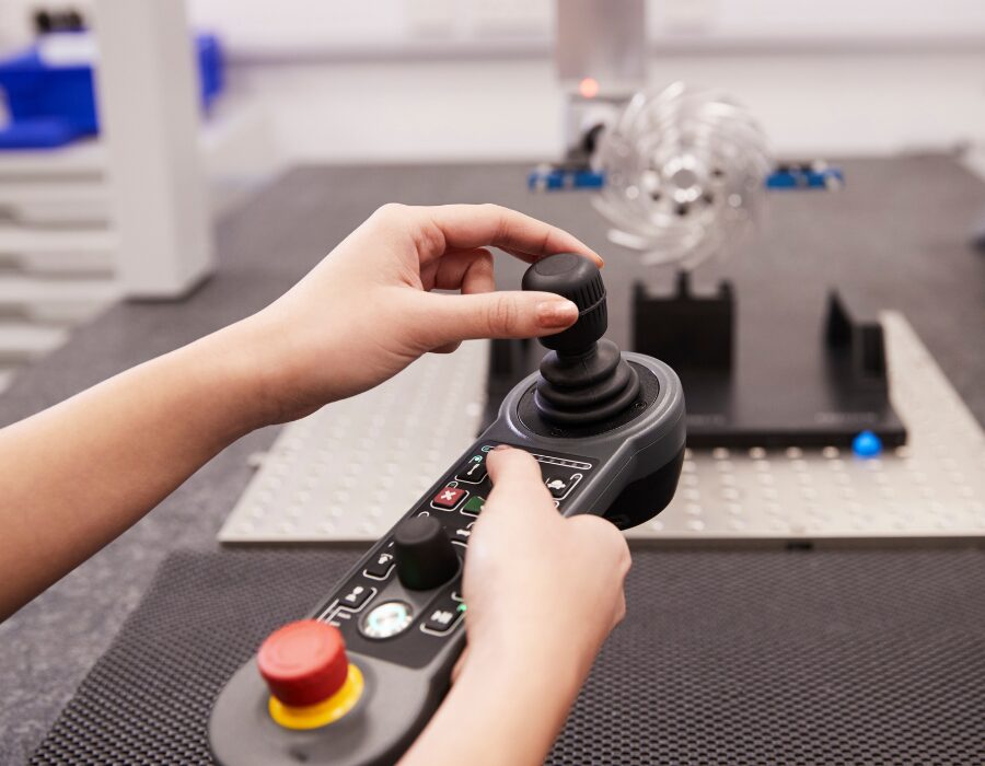 Hands operating a joystick control panel showing what is hall effect joystick.