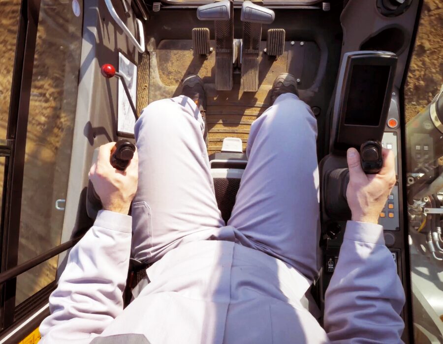 A person operates heavy machinery with an industrial joystick.