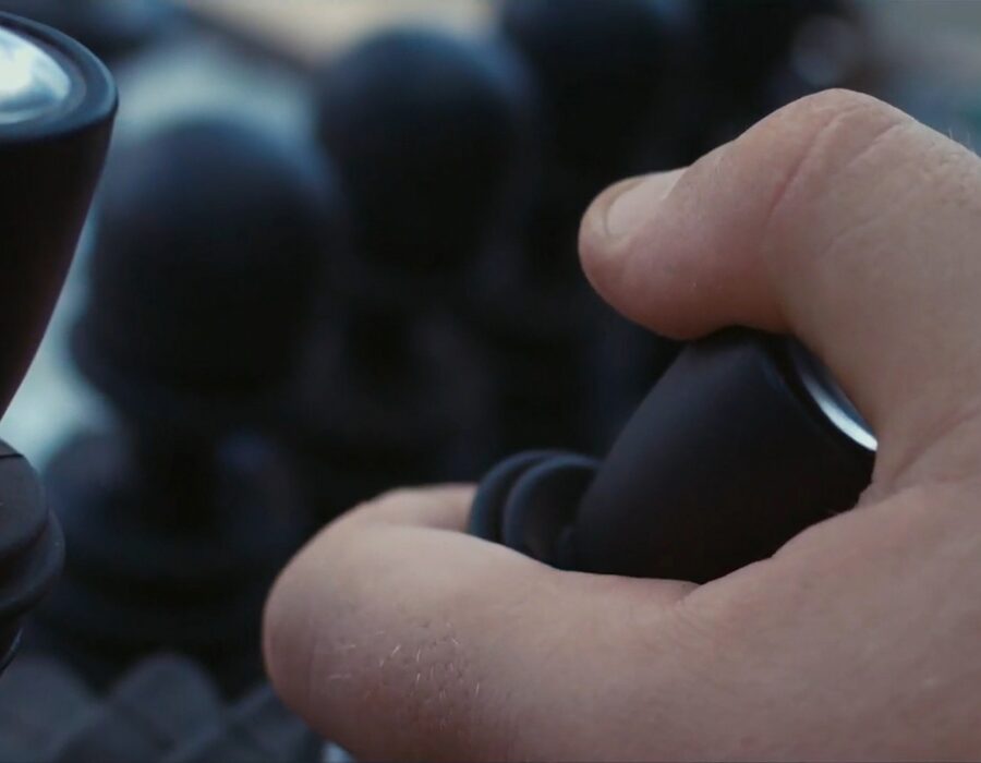 Close-up of hand operating an industrial joystick.